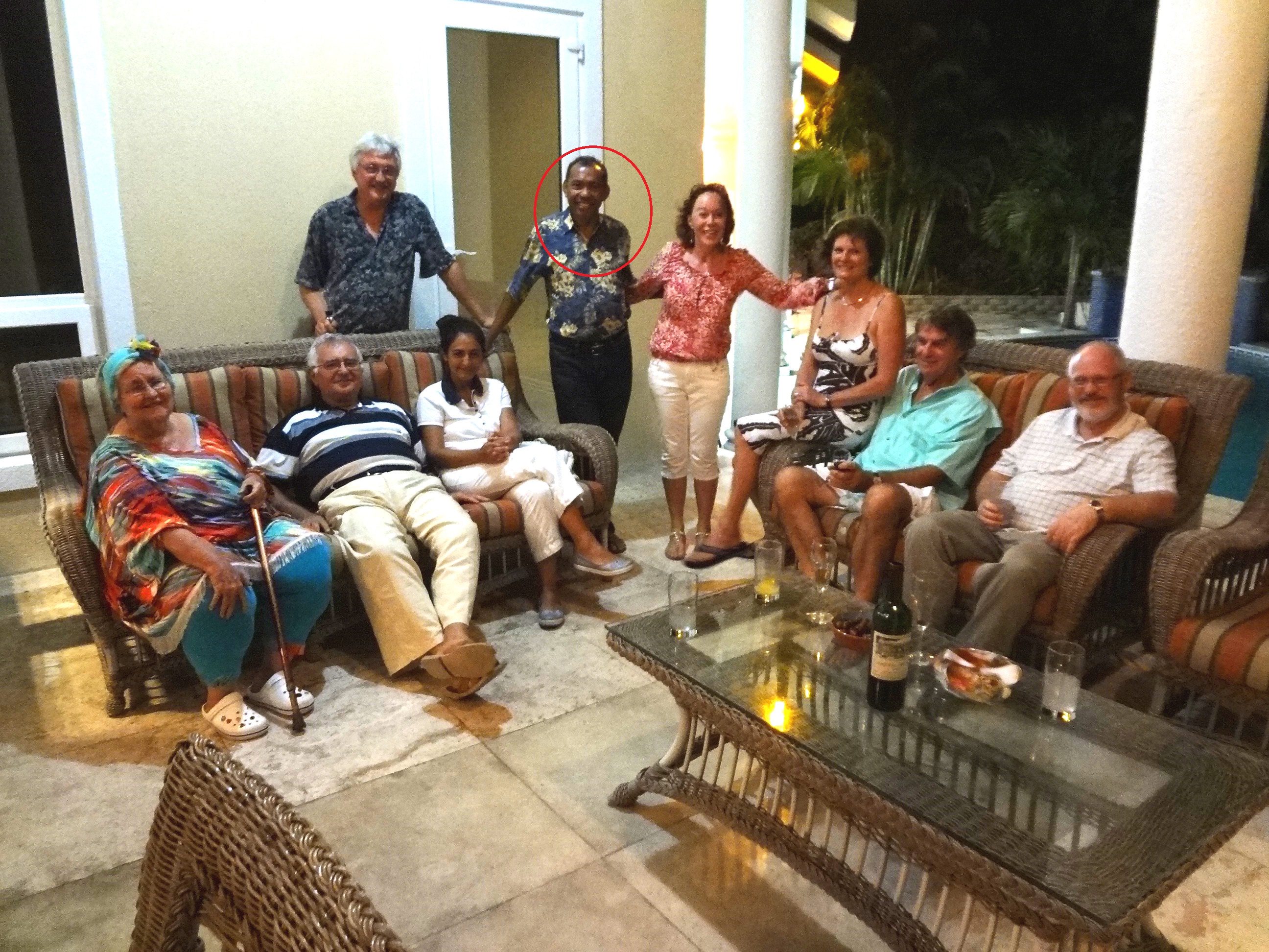 A very relaxed John Dalli, then still a European Commissioner, lies on a sofa in the Bahamas between two fraudsters, Mary Swan aka Lady Bird on the left and Mel Tari standing right, ringed in red. HIs daughter Louisa Dalli, wearing white, is seated near him.