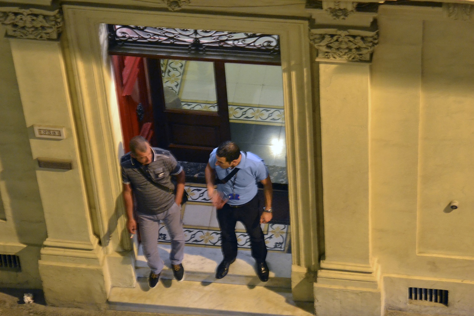 8.15pm - two police officers stand at the entrance to the building