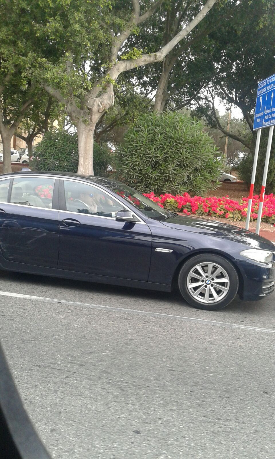 Photograph taken last June, showing the Economy Minister driving his heavily dented official car in the direction of his office, at 9am, with Dana Farrugia in the passenger seat.